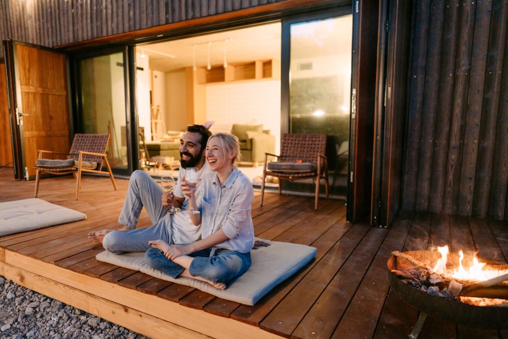 Young couple enjoying sunset on a wooden deck