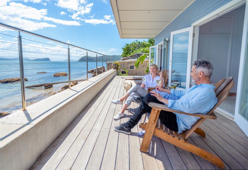 An older couple relaxes on a deck overlooking the ocean in Annapolis, MD.