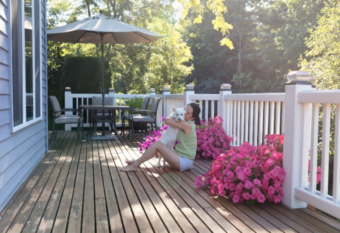 In Annapolis, MD, a woman relaxes on a deck with her dog, surrounded by a calm outdoor atmosphere.