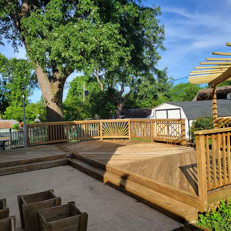 A wooden deck with a pergola and bench creates a welcoming outdoor area in Glen Burnie, MD.