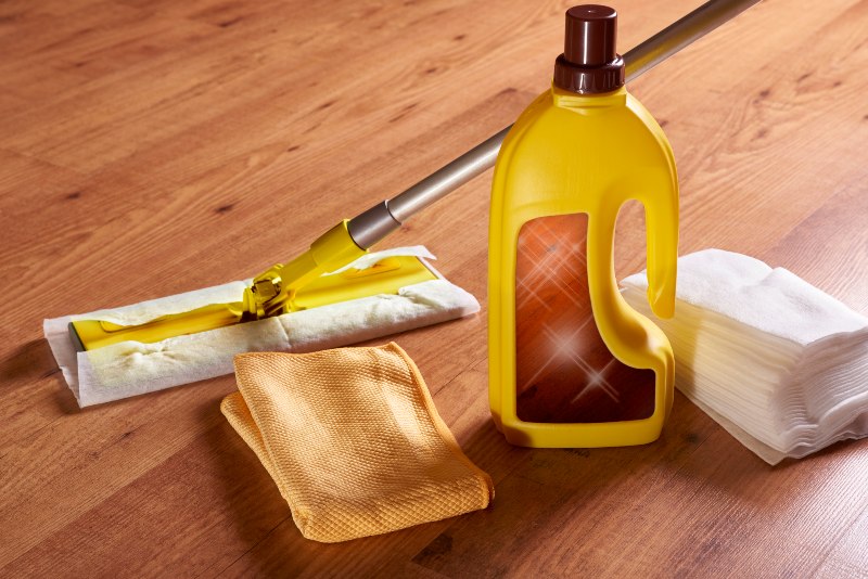 A Bottle of Cleaning Solution, a Mop, and a Cloth for Exotic Wooden Deck Care in Annapolis, MD