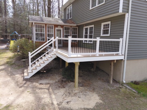 Contractor performing deck repair and renovation on an elevated outdoor structure